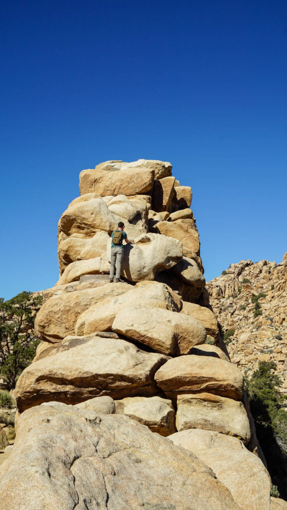 Alex as he is climbing over the boulders at Hidden Valley in Joshua Tree