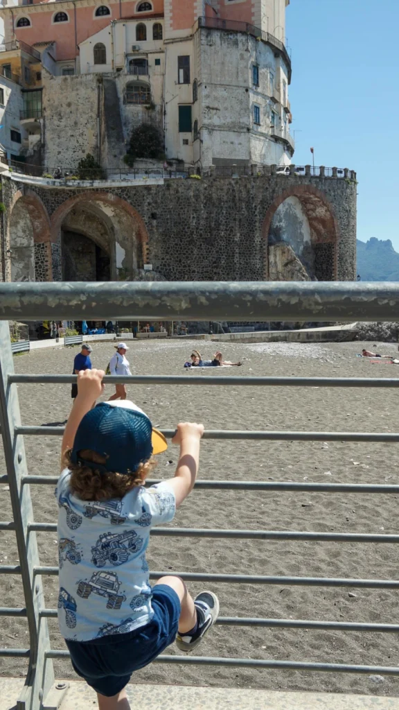 My son finding spots to climb in Amalfi Coast