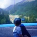 My son looking out towards Pirin Mountains while sitting on the gondola lift